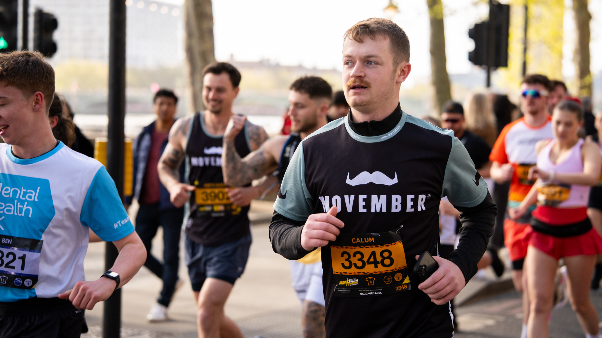 Movember runners in the foreground and background of a race event