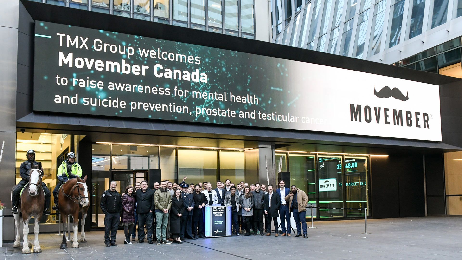 Photo of a group of people in front of the TMX Building entrance.