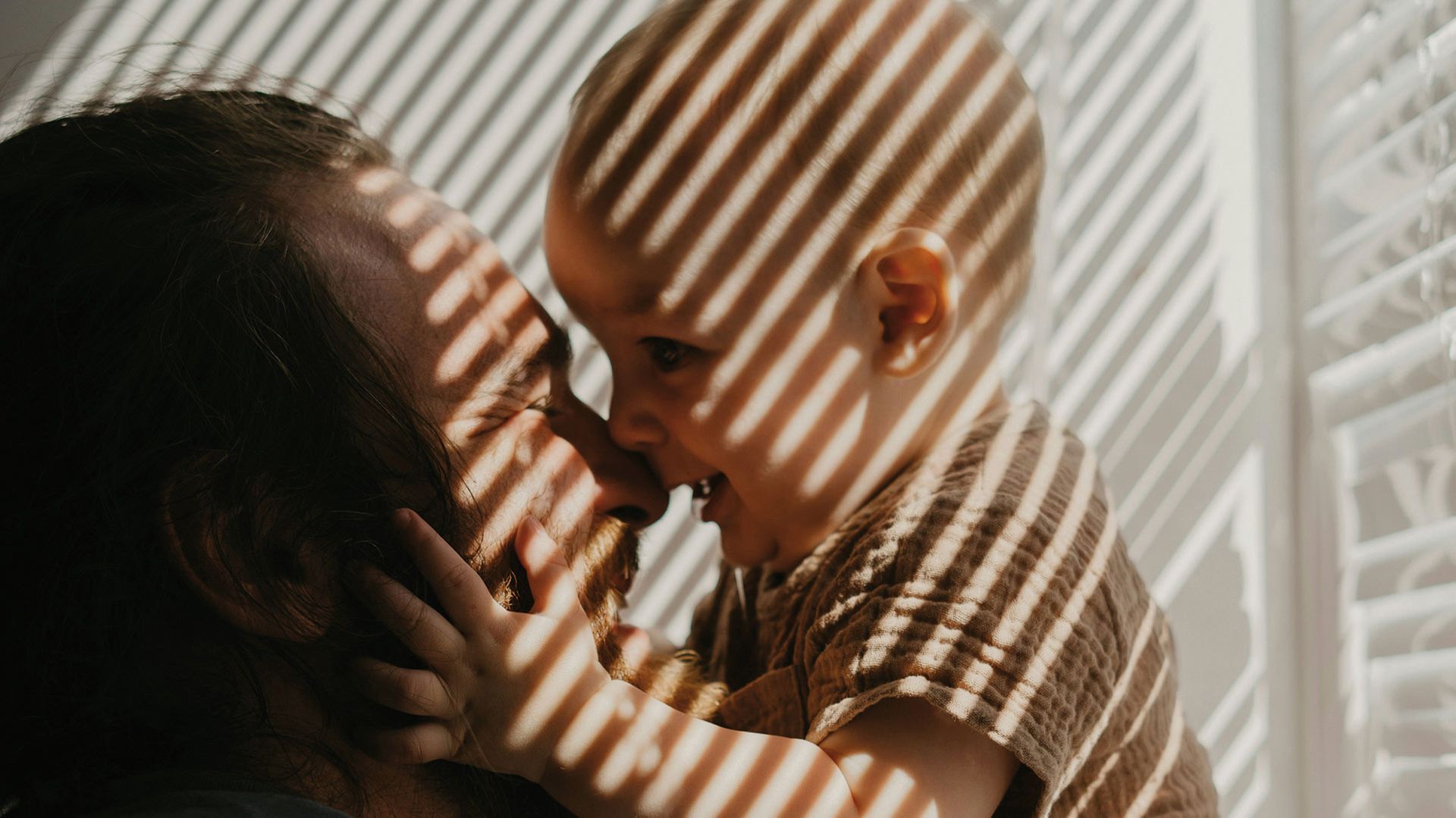 Photo of a father lovingly holding an infant.