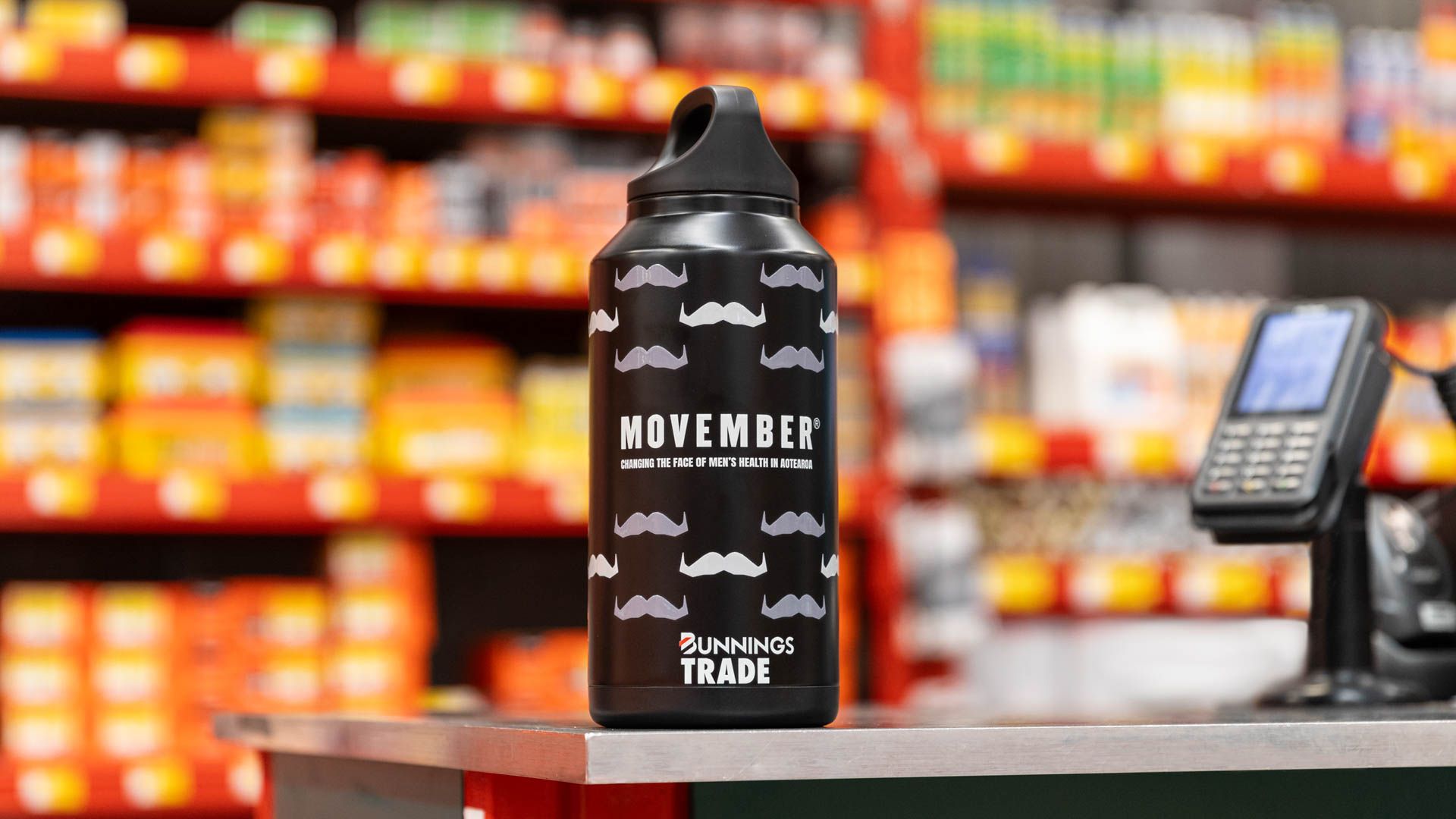 Photo of moustache-patterned drink bottle on top of counter.