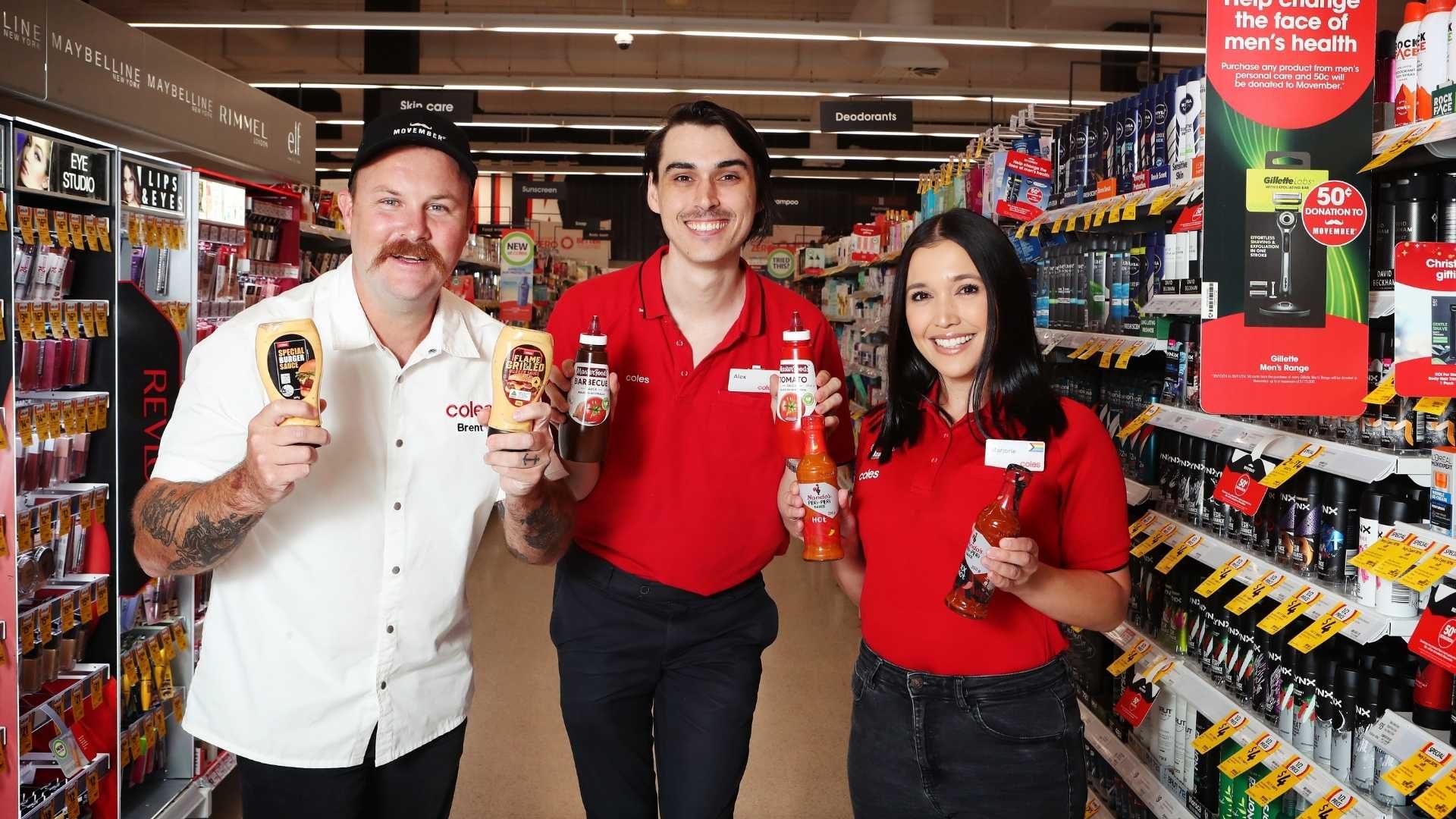 Photo of Coles personnel holding products that add donations to Movember.
