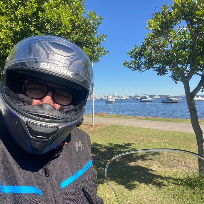 Photo of a man wearing a motorbike helmet and gear.