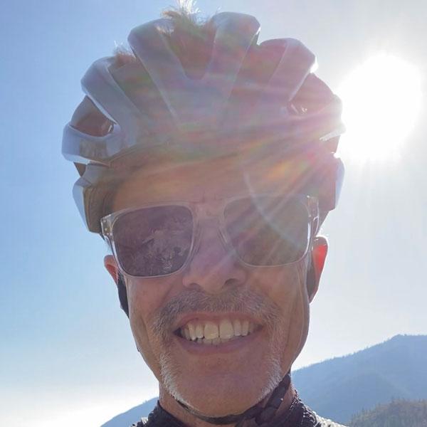 Cyclist in helmet looking to camera.