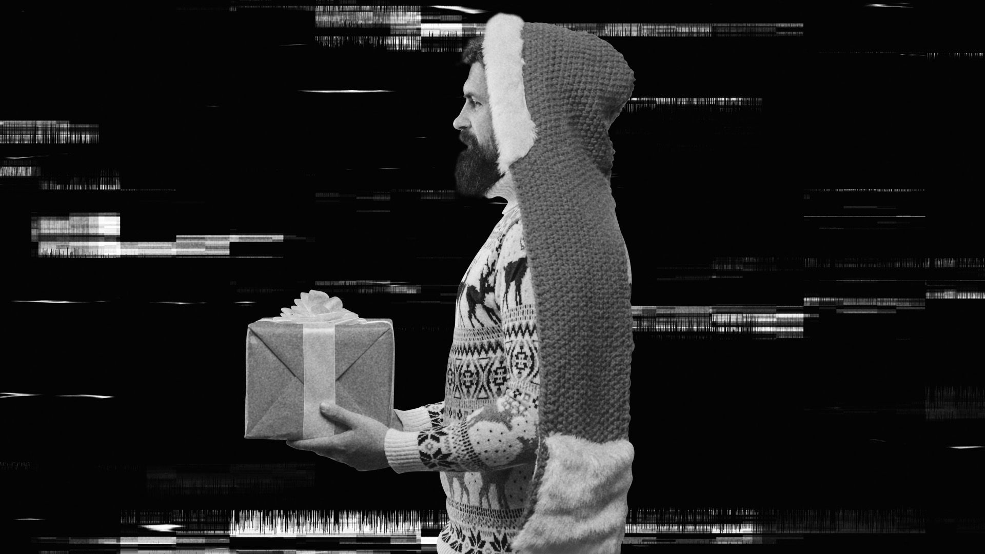 A photo of a man in a holiday sweater carrying a gift.