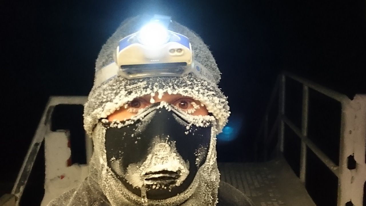 Man wearing ice-encrusted face covering looking to camera.
