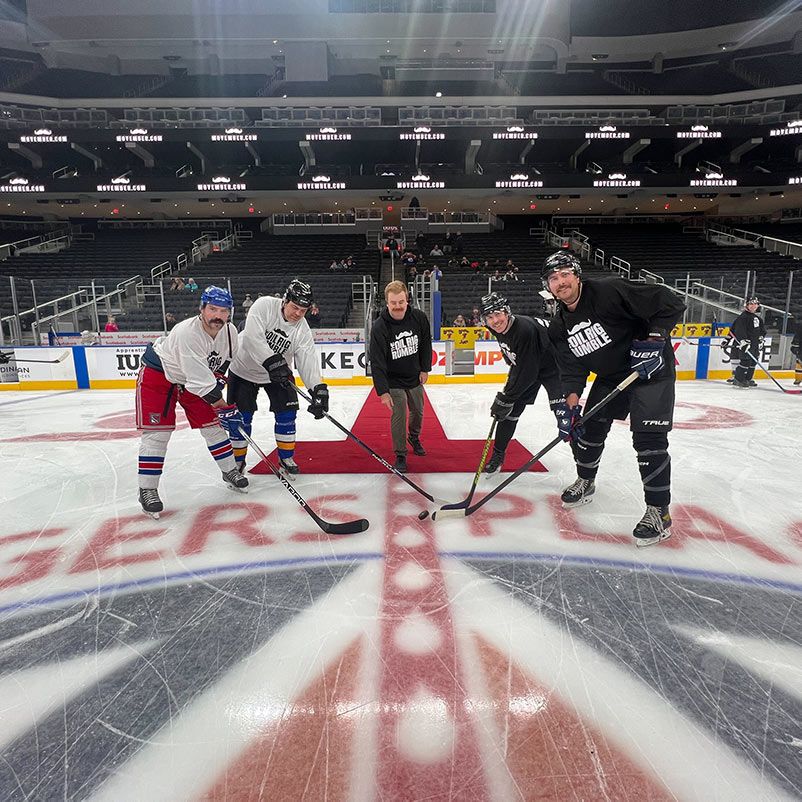 Photo of Oil Rig Rumble winners, wearing hockey gear, posing on the ice at Rogers Arena.