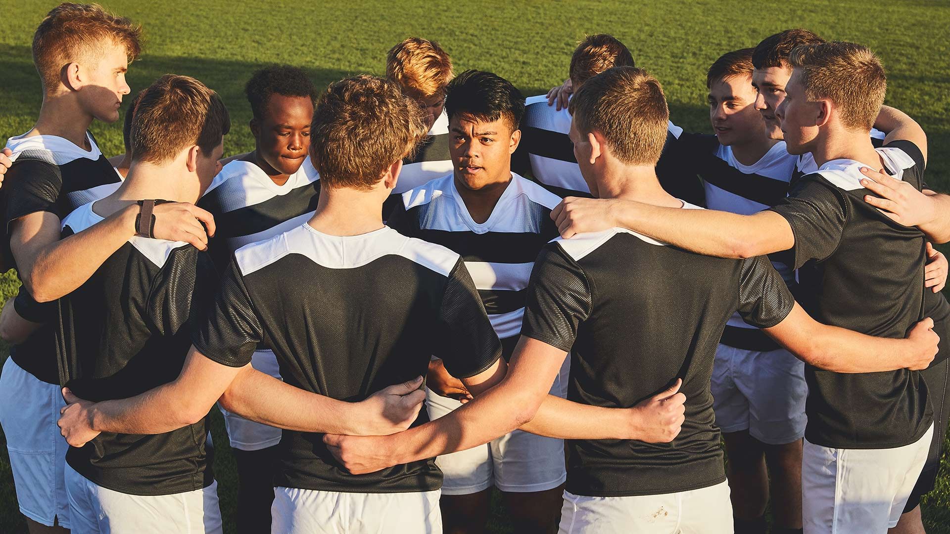 A group of young athletes in a huddle position