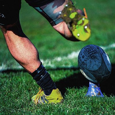 Photo of a rugby player about to kick a ball.